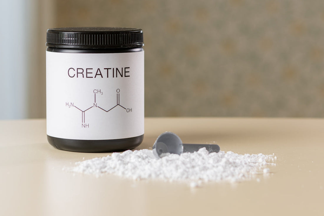 a bottle of creatine next to a spoon on a table.creatine benefits for muscle growth 