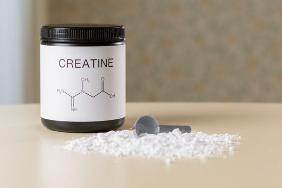 a bottle of creatine next to a spoon on a table.creatine benefits for muscle growth 