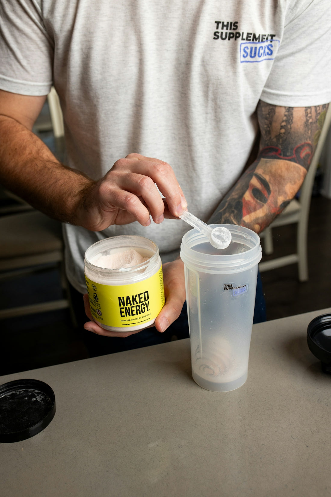 a man holding a container of whipped cream and a cup of coffee