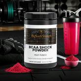 BCAA Shock Powder Fruit Punch for muscle recovery and growth, with shaker and scoop on gym mat