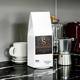Vitality Mushroom Coffee Medium Roast bag on marble counter with espresso maker and mug