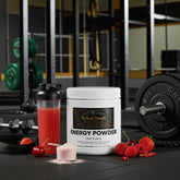 Energy Powder Fruit Punch supplement with mixed berries, gym equipment, and shaker bottle for workout fuel.